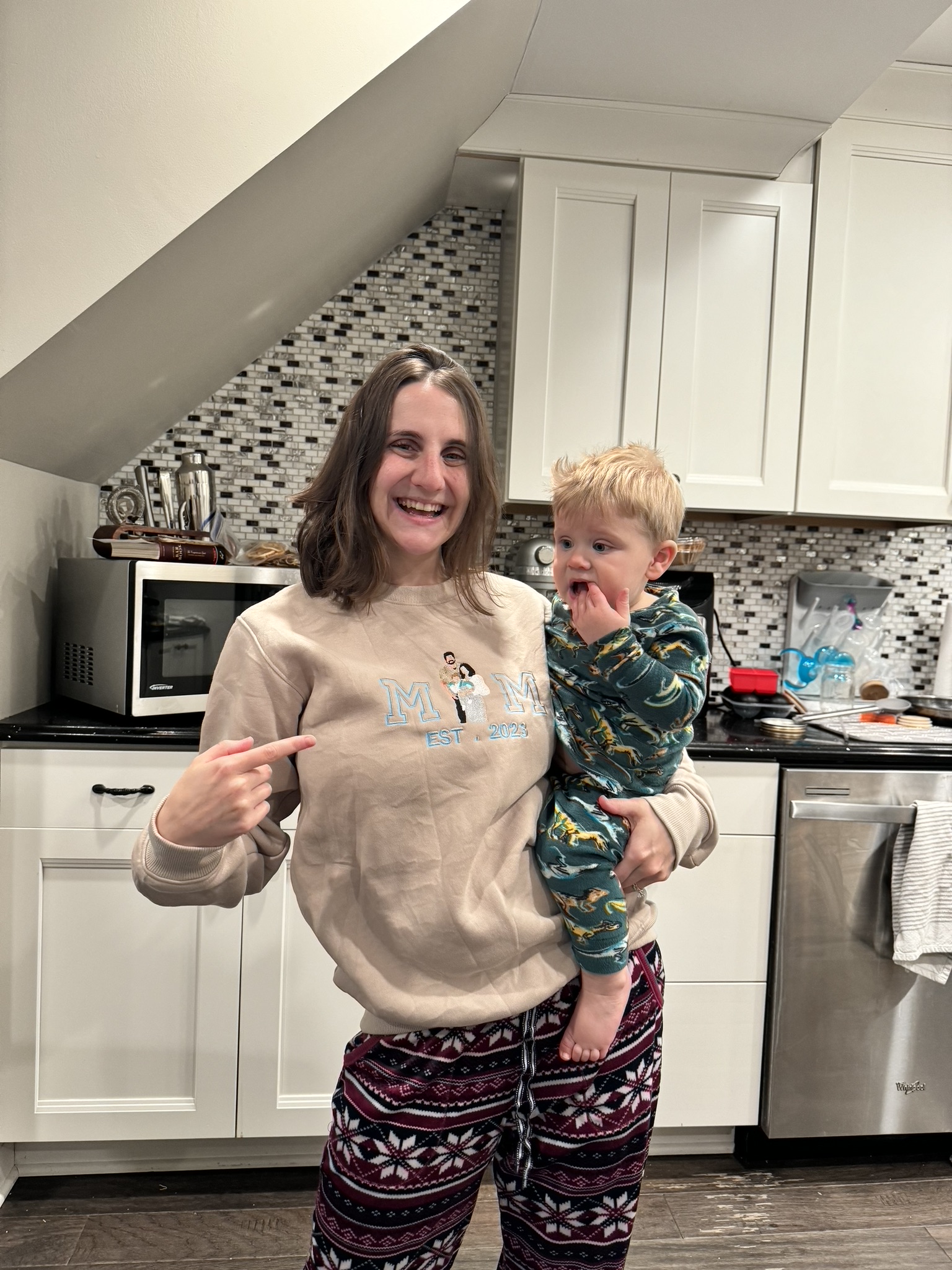 Rachel holding a toddler in the kitchen